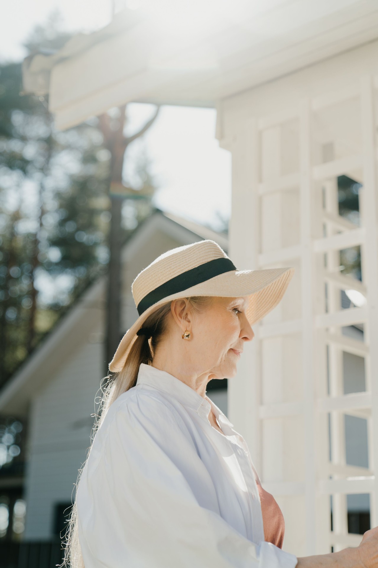 A woman resting peacefully on a sunlit porch.
